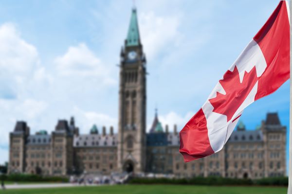 Scenic view of Parliament Hill with a Canadian flag waving.