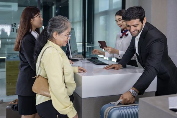 An airline agent helps a woman check in her luggage.
