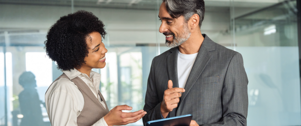 Male and Female professional discussing in an office.
