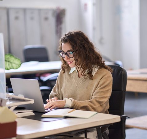 Young,Happy,Professional,Business,Woman,Employee,Sitting,At,Desk,Working Young Happy Professional Business Woman Employee Sitting At Desk Working
